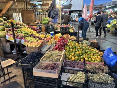 Рынок, где в ряд выложено большое количество фруктов.
